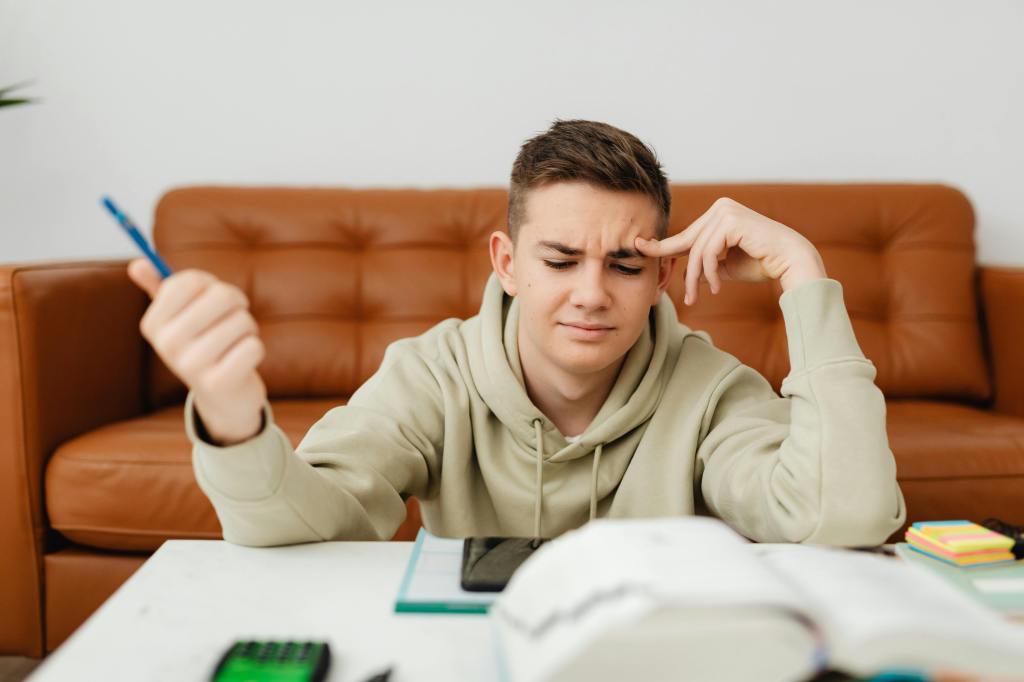 Teenage boy looking worried at school books. with thanks to karolina-grabowska and pexels.
